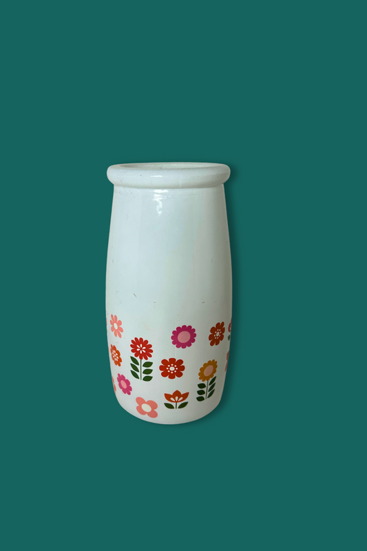White vase with floral patterns on a teal background