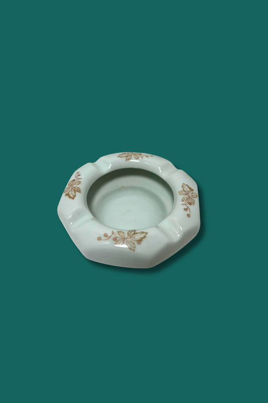 Decorative ceramic ashtray with floral patterns on a solid background