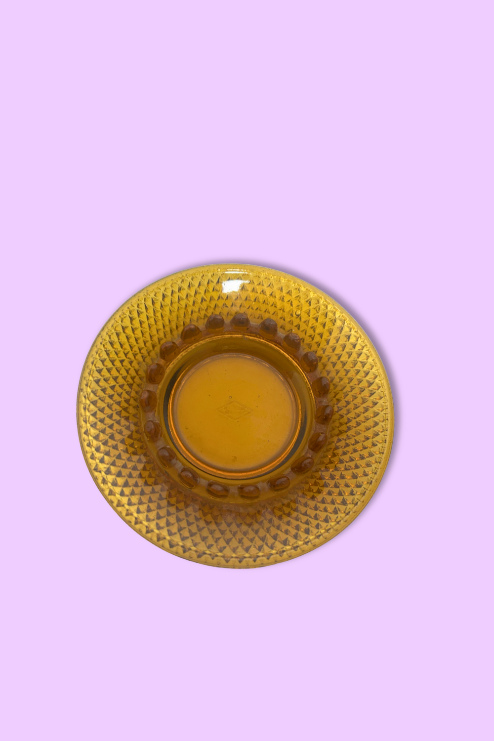 Yellow textured plate on a pink background