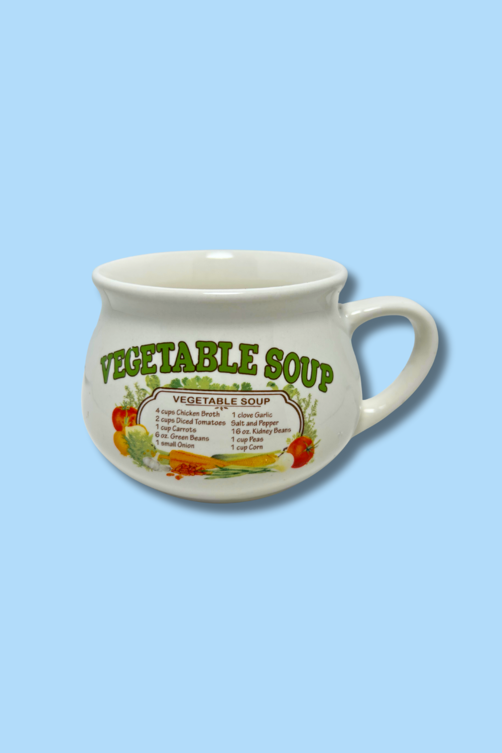 White ceramic mug with 'Vegetable Soup' text and ingredients on a light blue background