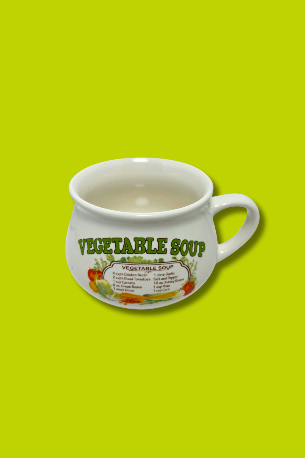 White ceramic cup labeled 'Vegetable Soup' on a green background