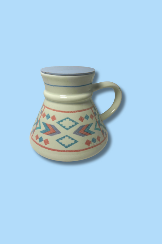 Ceramic mug with geometric patterns on a light blue background