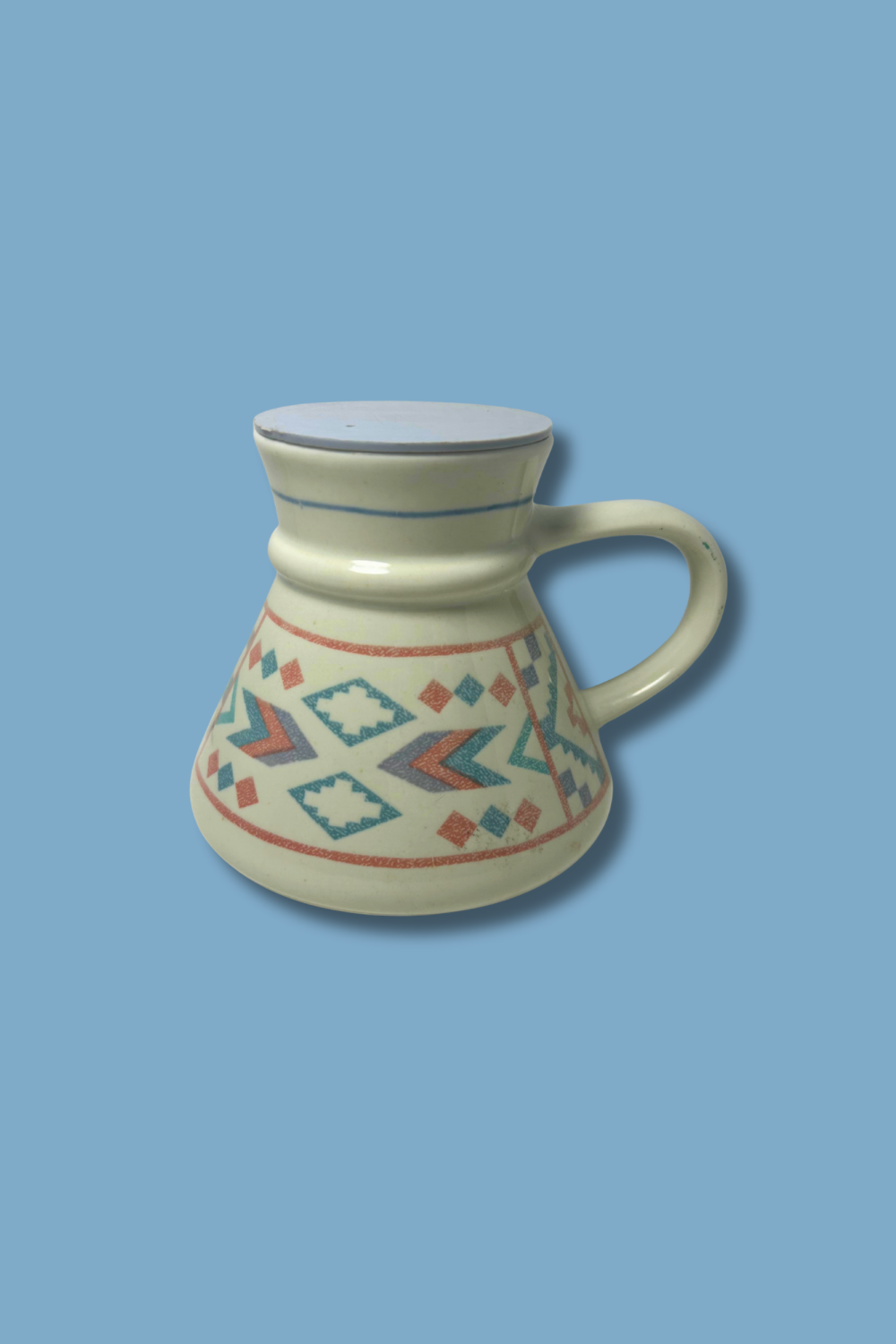 Ceramic mug with geometric patterns on a blue background