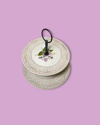 Stack of decorative plates with floral design on a pink background