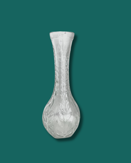 Clear glass vase on a teal background