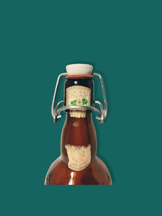 A vintage Grolsch beer bottle with a brown tint and decorative patterns, featuring a white cap and a label that partially shows the brand name.
