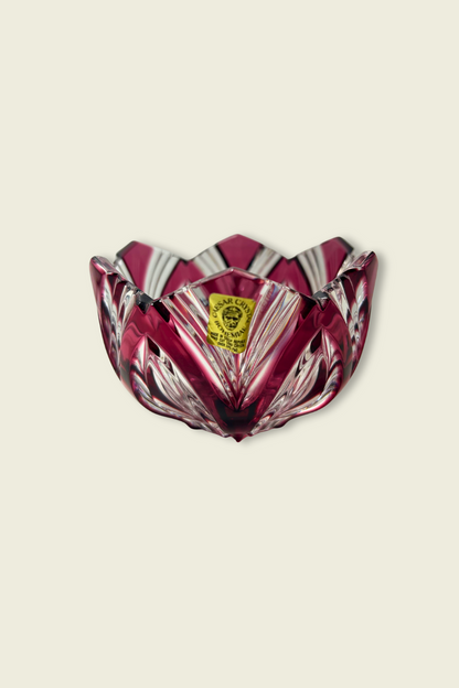 Decorative glass bowl with a red and clear pattern on a beige background