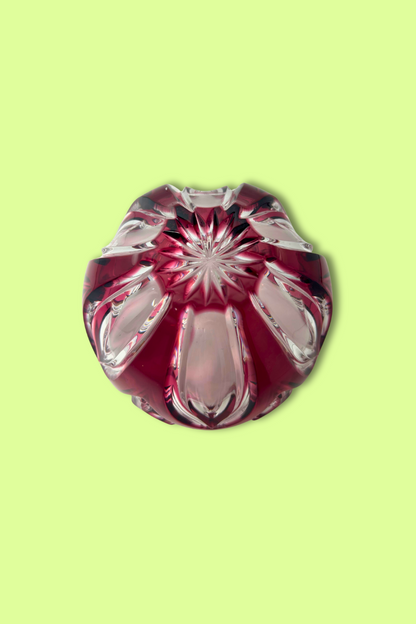 Decorative glass item with red and clear design on a light green background