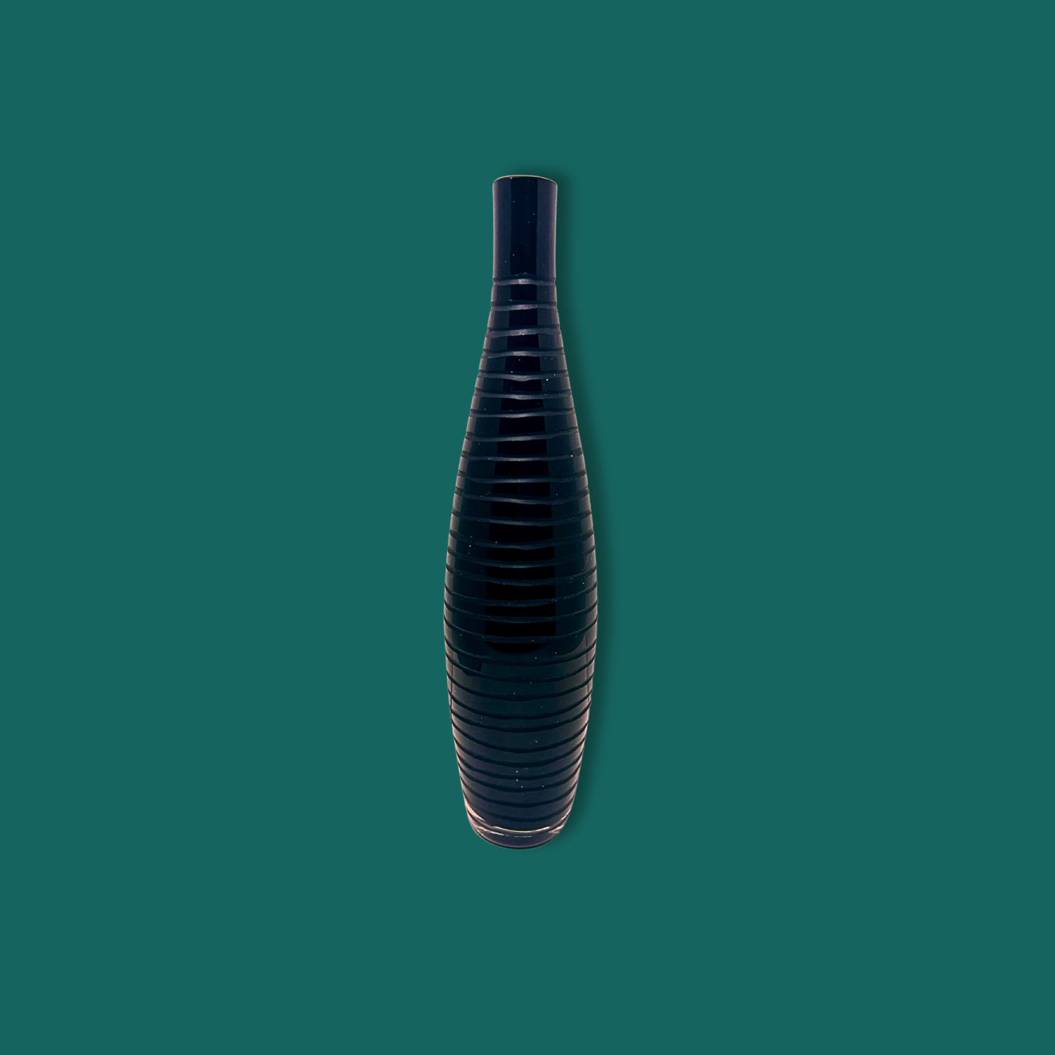 A black mid century modern Italian glass vase with etched lines, displayed against a green background.