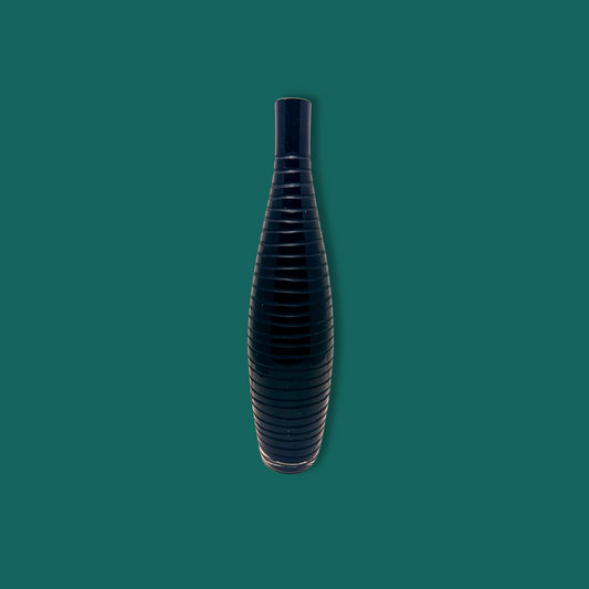 A black mid century modern Italian glass vase with etched lines, displayed against a green background.