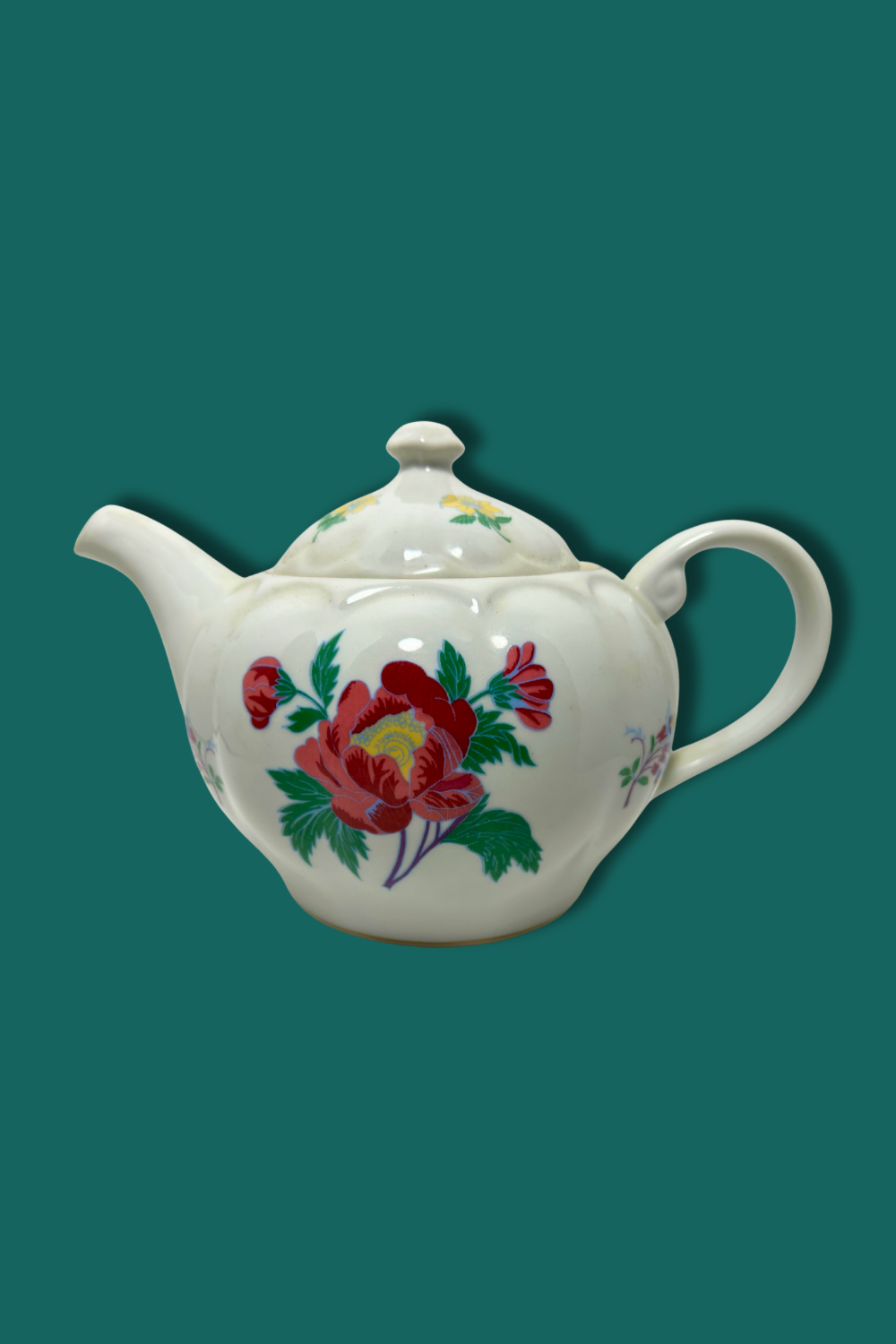 Teapot with floral design on a teal background