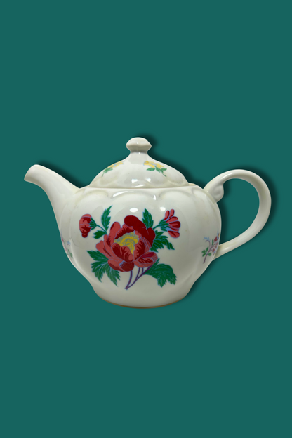 Teapot with floral design on a teal background