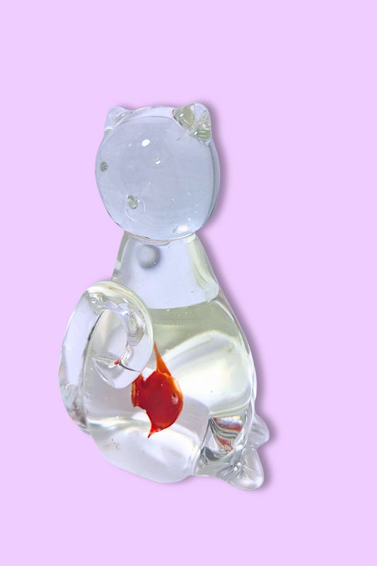 Glass sculpture of a cat with a red heart on a pink background