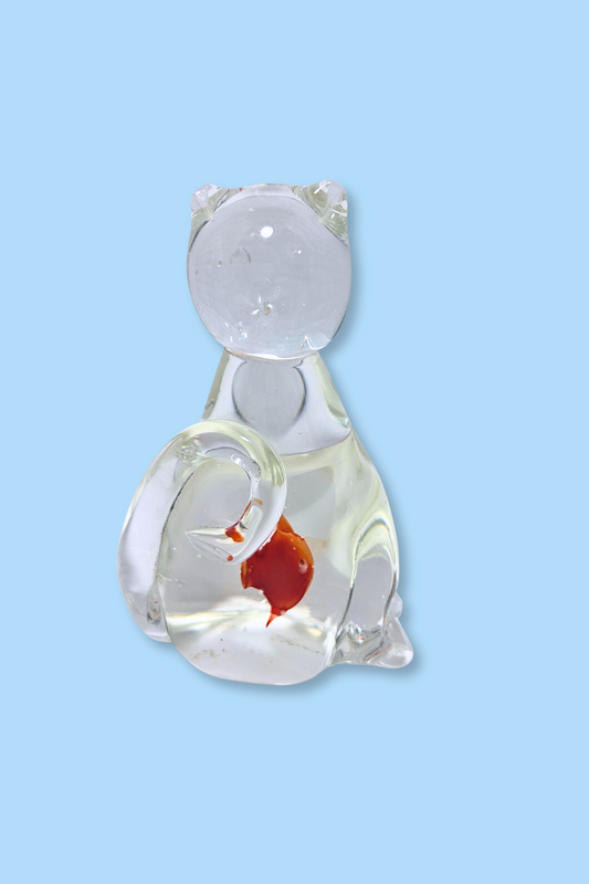 Glass cat figurine with a goldfish inside on a light blue background