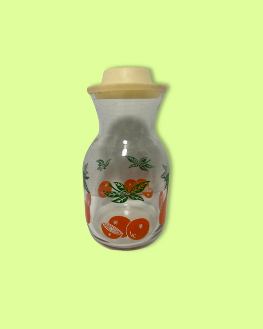 Decorative glass bottle with wooden lid on a light green background