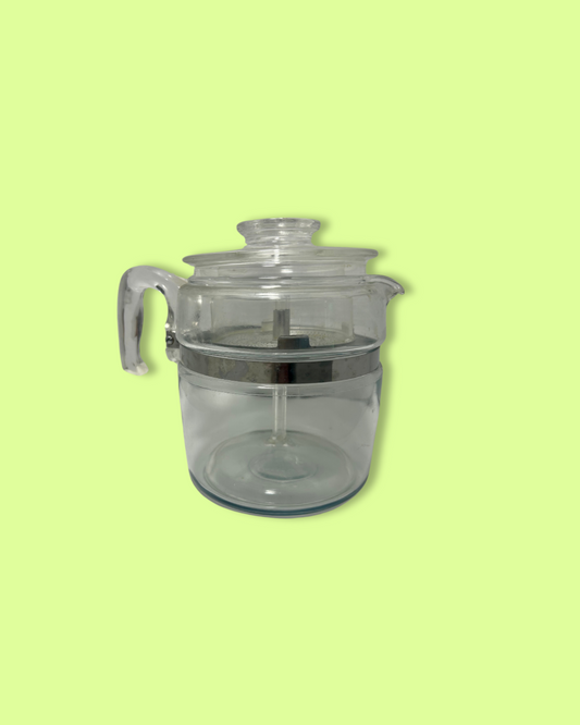 Clear glass pitcher with lid on a light green background