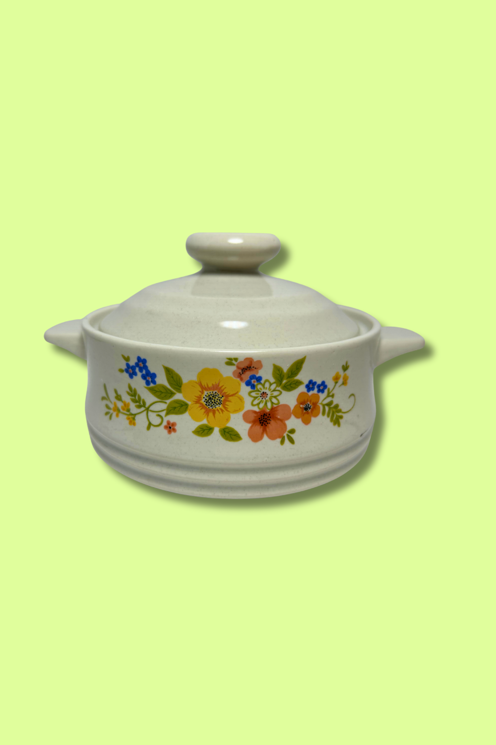 White ceramic casserole dish with floral design on a light green background