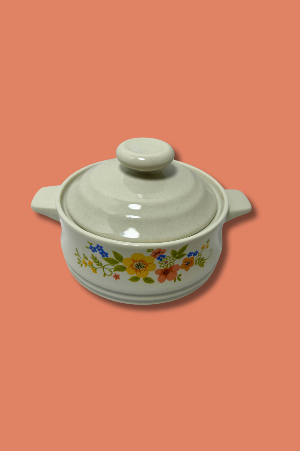 White ceramic casserole dish with floral patterns on a peach background