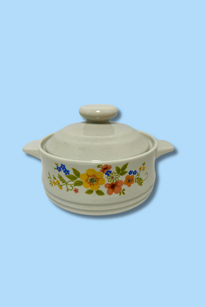 Ceramic casserole dish with floral design on a light blue background